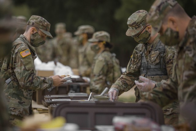 Soldiers in initial military training at Fort Jackson, S. C., line up to eat, May 11, 2020.
