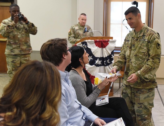 Col. Michael Clark, incoming commander, LOGCAP Support Brigade, gives a rose to his daughter during the LOGCAP Support Brigade change of command ceremony July 10 in Heritage Hall, Rock Island Arsenal, Illinois. (Photo by Jon Micheal Connor, ASC Public Affairs)