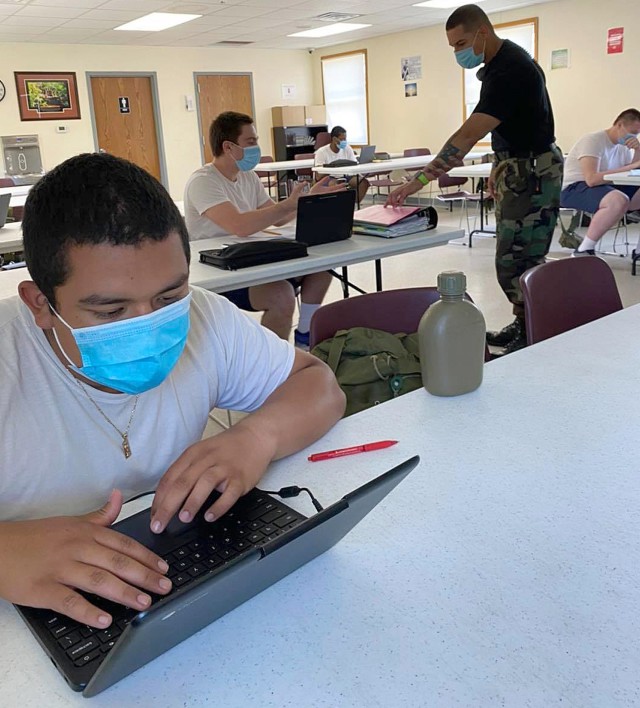 Team leader Heriberto Ruiz speaks with Wisconsin Challenge Academy cadet Dominick Bennett, as fellow cadet Luis Castro works to complete core requirements June 5 at Fort McCoy, Wis. The COVID-19 pandemic required the Academy to send its cadets...