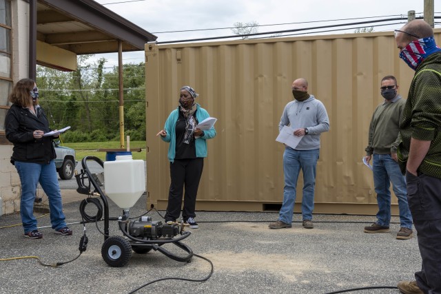Michelle Brain, Safety Engineer (far left), and Mumbi Thande-Kamiru, Technical Assistant to the Director (left), provide training on proper disinfecting processes as a part of the large-scale disinfecting program they helped to create for U.S. Army Aberdeen Test Center. The disinfecting program, designed to limit the potential spread of COVID-19 at the test center, determined effective and efficient disinfecting methods to ensure the test mission could continue safely. U.S. Army photo by ATC Technical Imaging Division