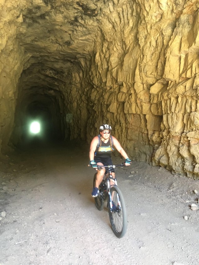 U.S. Army Spc. Jennifer Davenport, assigned to the Soldier Recovery Unit at Fort Carson, Colo., rides a mountain bike through a cave. Davenport began cycling while in the Army Recovery Care Program. (U.S. Army courtesy photo)