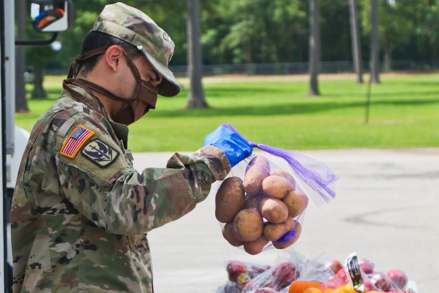 North Carolina Army National Guard Spc. Louis Merino, assigned to 2-130th Airfield Operations Battalion, sorts produce while working alongside volunteers from Team Rubicon, a veteran disaster relief service organization, Action Pathways, a non-profit organization, and the Second Harvest Food Bank Southeast to distribute food to approximately 250 families at the Midway Elementary School in Dunn, N.C., June 18, 2020. The NCNG is working with North Carolina Emergency Management, N.C. Department of Health and Human Services and local food banks to help support COVID-19 relief efforts. 