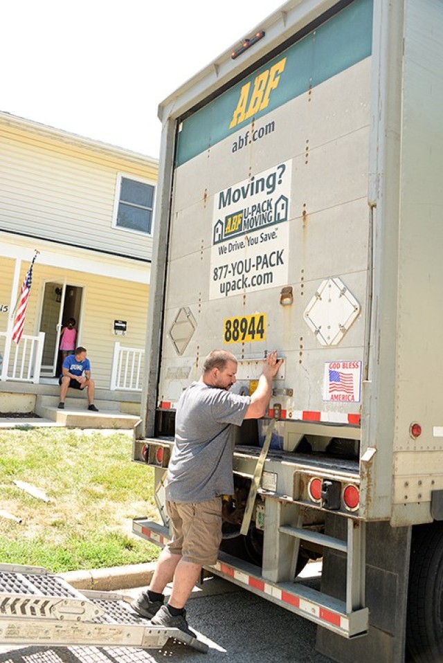 From their new porch, Maj. Ben Hunter, incoming Command and General Staff College student, and his 11-year-old daughter Cami watch ABF driver Ray Lilotta arrive with their household goods July 10 on post. With the ongoing COVID-19 threat, several incoming families have opted for DITY moves, some driving moving vans themselves and some hiring drivers to bring their self-packed household goods from post to post. Photo by Prudence Siebert/Fort Leavenworth Lamp