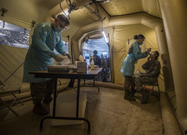 Pvt. Caleb Rice, left, and Spc. Crystal Gonzalez, right, assigned to the 44th Medical Brigade, conduct COVID-19 swab tests in the mobile testing center at the Javits Convention Center in New York City, May 29, 2020.