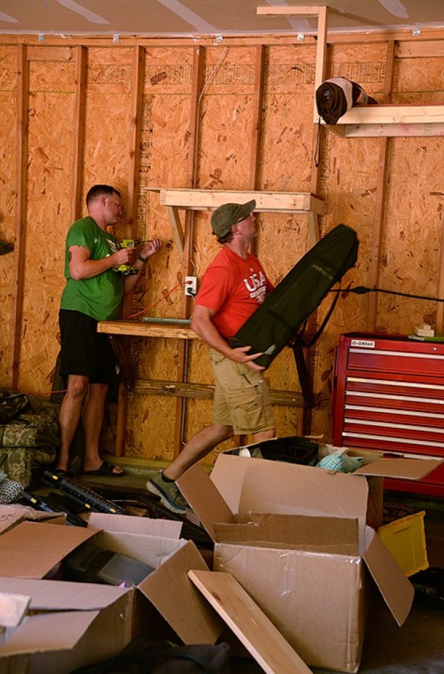 Maj. Mike Scaletty, incoming Command and General Staff Officer Course student, installs shelving while his brother, John Scaletty, from Fair Grove, Mo., organizes camping gear July 10 on post. John helped Mike with the do-it-yourself move from Fort Belvoir, Va., to Fort Leavenworth. Photo by Prudence Siebert/Fort Leavenworth Lamp
