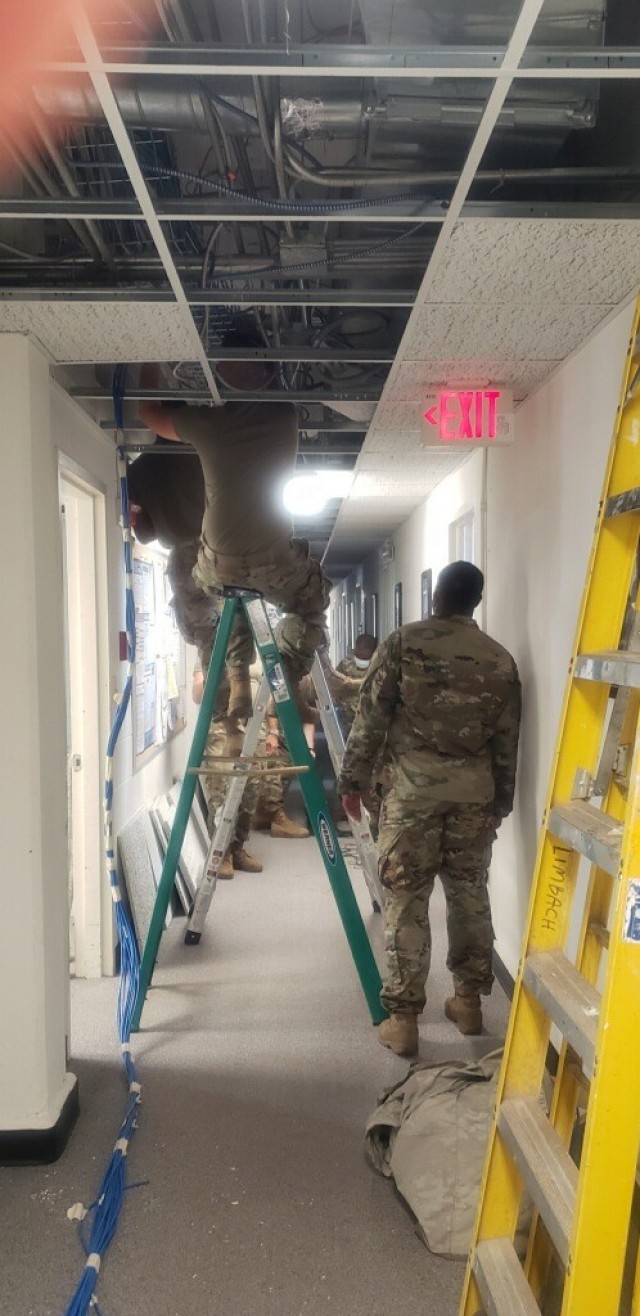 Soldiers running new Category 6 network cables. 