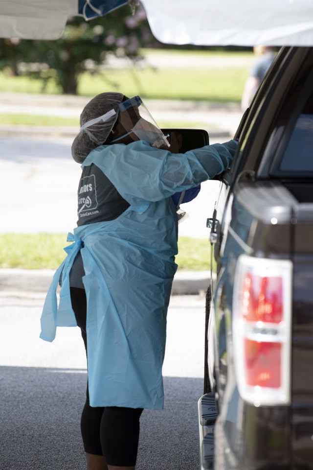 A health care professional reaches into a vehicle July 10 to administer COVID-19 testing July 10.