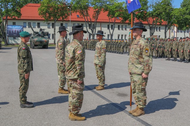 U.S. Army Command Sgt. Maj. Marcus Brister, assigned to 3rd Squadron, 2nd Cavalry Regiment, holds the Battle Group Poland colors before the ceremonial passing of the guidon during a change of command ceremony in Bemowo Piskie Training Area, Poland, July 17, 2020. After a 6-month rotation, 3rd Squadron, 2nd Cavalry Regiment was replaced by 2nd Squadron, 2nd Cavalry Regiment. (U.S. Army photo by Cpl. Justin W. Stafford)