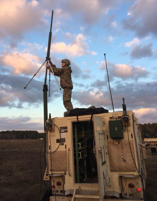 Spc. Todd Callahan, a signal support systems specialist with the Mission Command Element, 1st Infantry Division, out of Fort Riley, Kans., stands on top of a Command Post Platform vehicle to set up an antenna to allow radio communication during a command post exercise. Focused on validating technologies in support of the Integrated Tactical Network, NetModX serves as the C5ISR Center’s accountability event every year. 