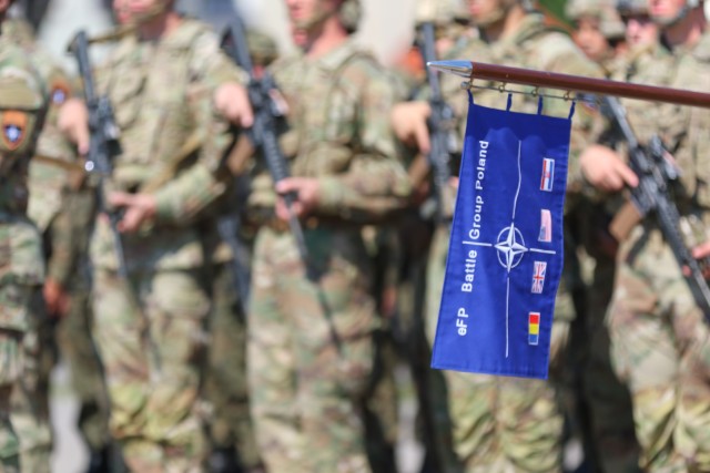 The enhanced Forward Presence Battle Group Poland guidon is held in front of a formation of Soldiers during a change of command ceremony in Bemowo Piskie Training Area, Poland, July 17, 2020. After a 6-month rotation, 3rd Squadron, 2nd Cavalry Regiment was replaced by 2nd Squadron, 2nd Cavalry Regiment. (U.S. Army photo by Cpl. Justin W. Stafford)