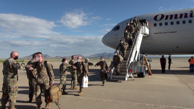 Soldiers from Alpha Company, 40th Expeditionary Signal Battalion exit an aircraft at Libby Army Airfield as they redeploy to Fort Huachuca, Ariz.