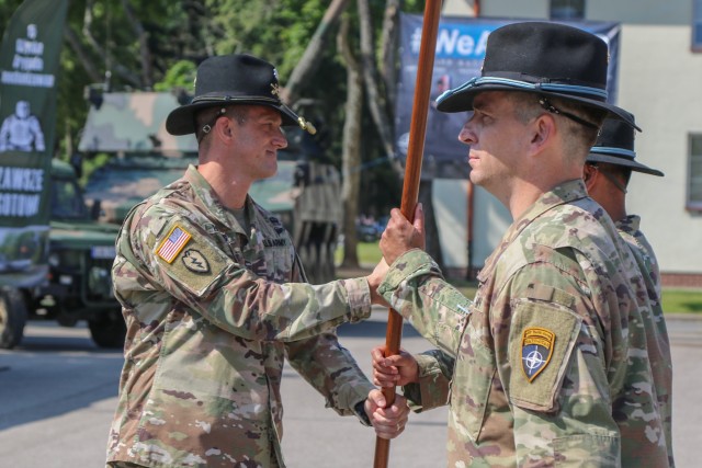 U.S. Army Lt. Col. Jeffery Higgins, the incoming Battle Group Poland commander, passes a guidon to Command Sgt. Maj. Keneti Pauulu, the incoming command sergeants major for the battle group, during a change of command ceremony in Bemowo Piskie Training Area, Poland, July 17, 2020. After a 6-month rotation, 3rd Squadron, 2nd Cavalry Regiment was replaced by 2nd Squadron, 2nd Cavalry Regiment. (U.S. Army photo by Cpl. Justin W. Stafford)