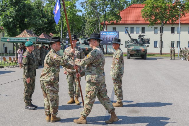 U.S. Army Command Sgt. Maj. Marcus Brister, assigned to 3rd Squadron, 2nd Cavalry Regiment, passes a guidon to Lt. Col. Andrew Gallo, the 3/2 CR and outgoing Battle Group Poland commander, during a change of command ceremony in Bemowo Piskie Training Area, Poland, July 17, 2020. After a 6-month rotation, 3rd Squadron, 2nd Cavalry Regiment was replaced by 2nd Squadron, 2nd Cavalry Regiment. (U.S. Army photo by Cpl. Justin W. Stafford)