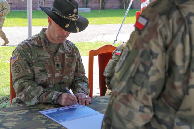 U.S. Army Lt. Col. Andrew Gallo, 3rd Squadron, 2nd Cavalry Regiment commander and outgoing Battle Group Poland commander, signs a transfer of authority during a change of command ceremony in Bemowo Piskie Training Area, Poland, July 17, 2020....
