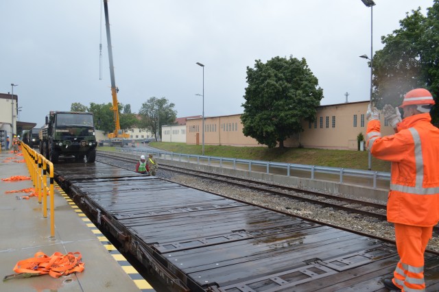 A Deutsches Bahn railroad employee guides a truck while it is offloaded from a train July 16, 2020, during the largest rail operation U.S. Army Garrison Ansbach, Germany, conducted in more than 10 years. The trucks and equipment belong to the 101st Combat Aviation Brigade, the incoming Regionally Allocated Force that will be stationed at Storck Barracks, Illesheim, for their nine-month rotation supporting Atlantic Resolve. The Katterbach Railhead provides U.S. Army in Europe an additional power projection platform capability to deploy arriving and departing brigade-size elements to meet strategic objectives.
