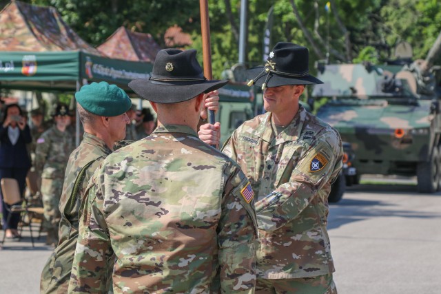 Polish Land Forces Col. Bogdan Rycerski, 15th Mechanized Brigade commander, passes a guidon to the incoming Battle Group Poland commander, Lt. Col. Jeffery Higgins, assigned to 2nd Squadron, 2nd Cavalry Regiment, during a change of command ceremony in Bemowo Piskie Training Area, Poland, July 17, 2020. After a 6-month rotation, 3rd Squadron, 2nd Cavalry Regiment was replaced by 2nd Squadron, 2nd Cavalry Regiment. (U.S. Army photo by Cpl. Justin W. Stafford)