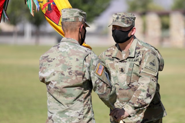 FORT BLISS, Texas - Command Sgt. Maj. Robert Cobb, the outgoing senior enlisted advisor of 1st Armored Division and Fort Bliss, right, is given the 1AD colors by Sgt. Maj. Joseph Denny, the 1AD operations sergeant major, during a change of...