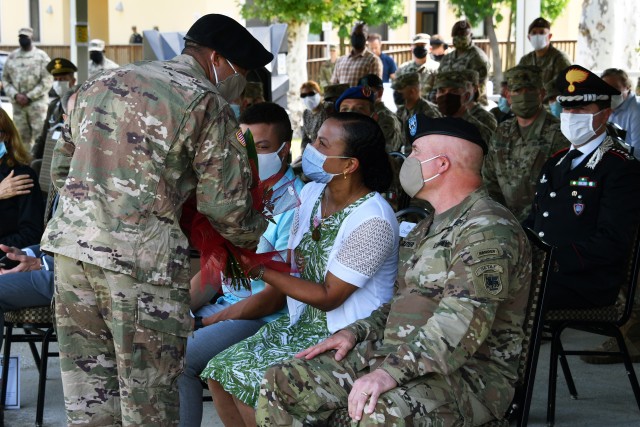 U.S. Army Staff. Sgt. Tyree Norwood, assigned to the U.S. Army Africa and the NCO winner of the USARAF Best Warrior Competition, presents Diane Cloutier with a bouquet of red roses signifying the bonds of appreciation and respect for her dedicated...