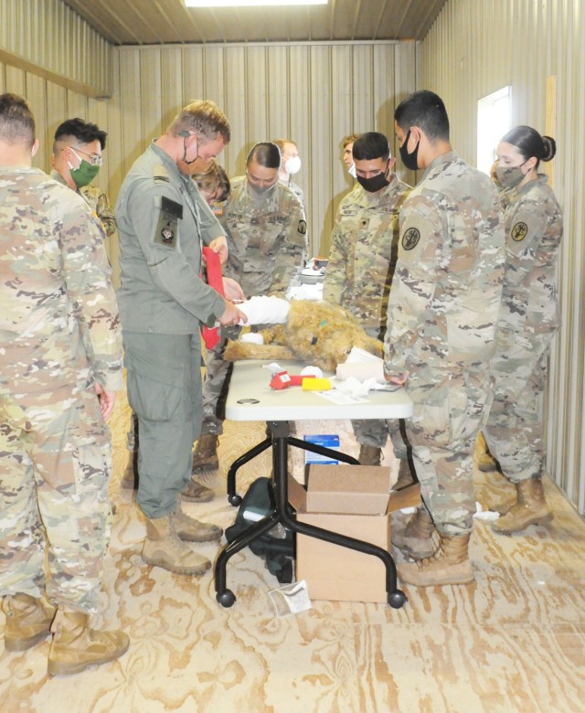 K-9 tactical combat casualty care class students practice applying a splint on a dog dummy July 9 at the Bayne-Jones Army Community training site.