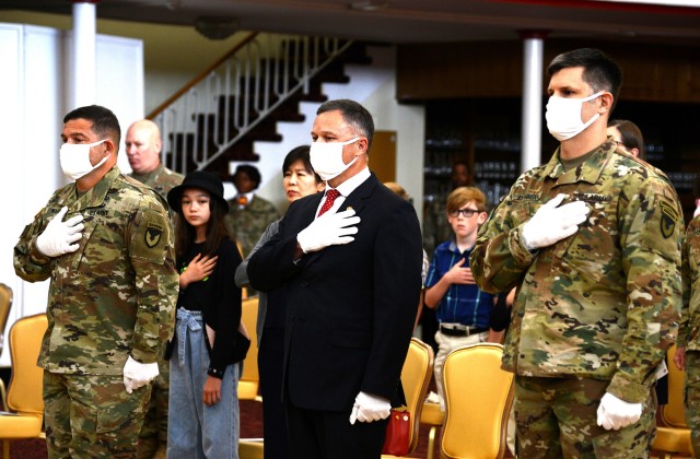 Tommy Mize, IMCOM-E director, center, stands with Col. Jason Edwards, outgoing USAG Rheinland-Pfalz commander, left, and Col. Vance Klosinski, new USAG Rheinland-Pfalz commander during the national anthem before the change of command ceremony July...