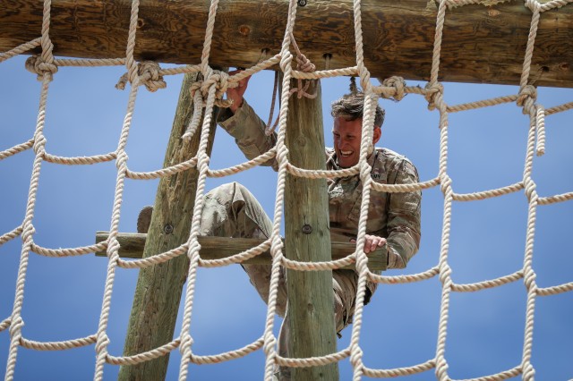 FORT BLISS, Texas - Staff Sgt. James Ferrone, a cavalry scout assigned to Troop B, 2nd Squadron, 13th Cavalry Regiment, 3rd Armored Brigade Combat Team, 1st Armored Division and native of Naperville, Illinois, climbs a wooden ladder as part of the Fort Bliss obstacle course during the 1AD Best Warrior Competition, May 15. The obstacle course was conducted after a 12-mile ruck march and the Army Combat Fitness Test, pitting the competitors through a final grueling physical event designed to test their physical and mental resiliency as well as perseverance. The obstacle course included climbing ropes, scaling barriers and balance obstacles, most of which included an element of heights in order to test a Soldier’s confidence and resolve. The competitors completed the course in the best possible time, with their results being combined with the other events, and an interview with the division operations sergeant major, which collectively tested their physical endurance, competence, and Soldier skills in order to determine the 1AD Soldier and Noncommissioned Officer of the year. Ferrone won the competition along with Spc. Gage Paraschos, a native of Mount Bethel, Pennsylvania and cavalry scout assigned to Troop C, 2-13 CAV, demonstrating continued excellence and determination which represents the very best of 1AD. (U.S. Army photo by Pfc. Matthew Marcellus)