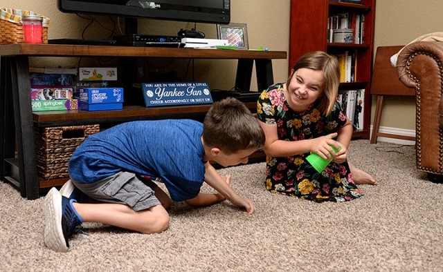 Nine-year-old twins Timothy and Victoria Kallo vie for a cup, with Victoria grabbing it first, while playing the Vacation Bible School game "Head, Shoulders, Cup" July 21 at their on-post home. VBS was offered virtually this year in an online...