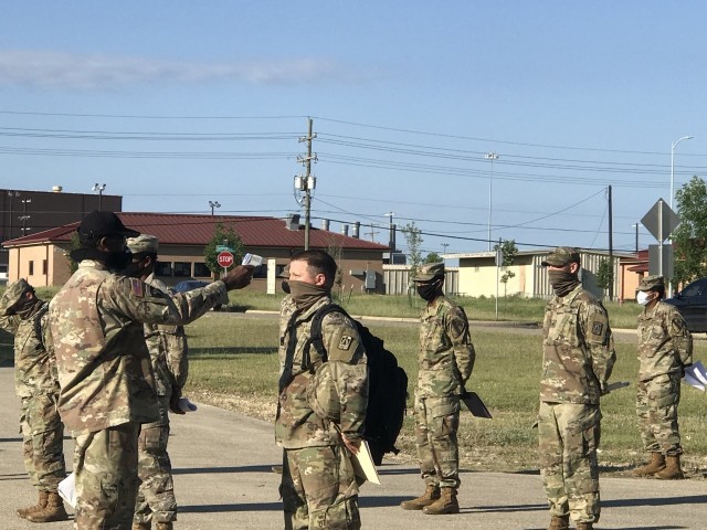 An instructor assigned to a brigade within the 94th Training Division - Force Sustainment (TD-FS) checks the temperature of students attending a course at Fort Hood, Texas, May 6-22, 2020. For the 2nd Brigade (Transportation), 94th TD-FS new commander, Lt. Col. Eddie Smith is more focused on Soldiers and their well being versus a a change of command ceremony.