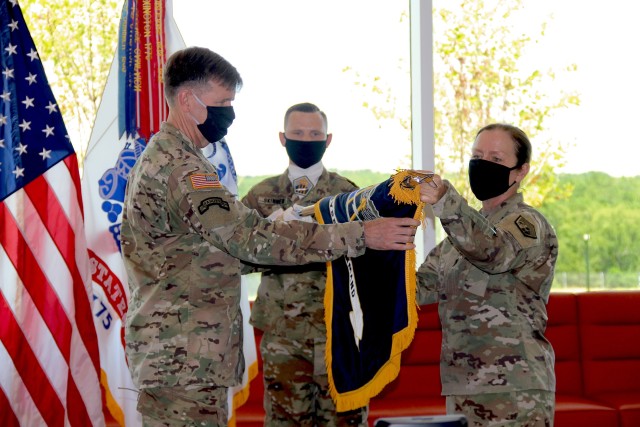 Lt. Gen. Stephen G. Fogarty, commander of U.S. Army Cyber Command (left) and ARCYBER senior enlisted leader Command Sgt. Maj. Sheryl D. Lyon (right) unfurl the ARCYBER colors in the command's new headquarters at Fort Gordon, Ga., July 24, 2020. The brief ceremony marked ARCYBER's official relocation to Georgia from the Washington, D.C. area, where its headquarters and other command elements have been stationed since ARCYBER's founding in 2010. (Photo by Staff Sgt. Michel'le Stokes)