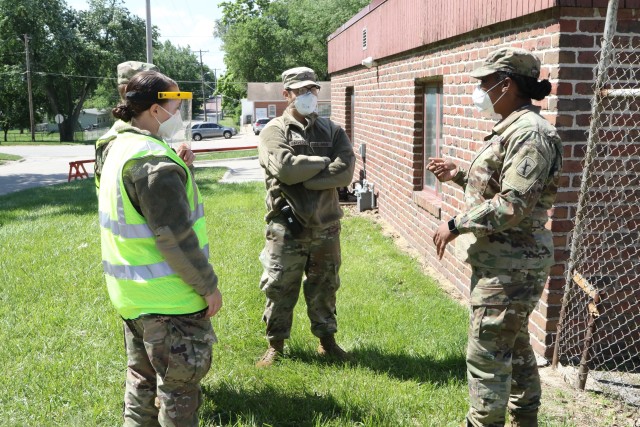 Maj. Elizabeth Davis, (right), an Army behavioral sciences officer, speaks with Nebraska National Guard Soldiers and Airmen, June 10, 2020, about the status of their missions at a mobile testing site in Nebraska City, Neb. The Nebraska National Guard has multiple teams supporting the Nebraska Department of Health and Human Services with COVID-19 mobile testing across the state. 