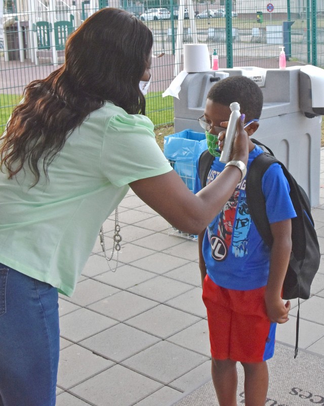 WIESBADEN, Germany - Hazel Ann Swan, supervisory program specialist at the Child Development Center, takes a child’s temperature July 24 during morning drop off. CDCs at U.S. Army Garrison Wiesbaden have implemented safety measures as they...