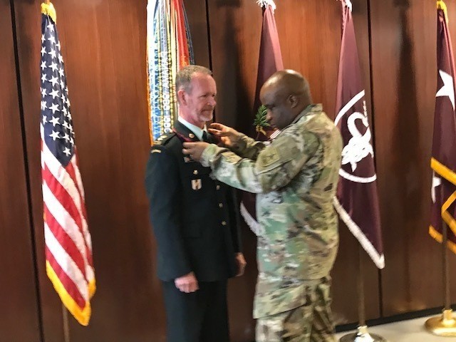 Lt. Col. Andrew Currie, Canadian Defense Attaché (DATT) Medical Staff Officer and Medical Liaison Officer to Health Affairs/Defense Health Agency (DHA) receives the Order of Military Medical Merit (O2M3) from Col. Dubray Kinney, Director of...