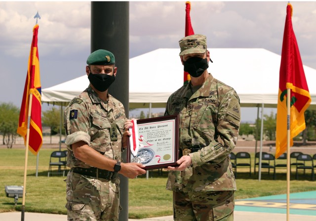 Fort Bliss, Texas - Maj. Gen. Patrick Matlock, the commanding general of 1st Armored Division and Fort Bliss (right), awards the Order of St. George to British Army Brigadier Leigh Tingey, a native of Cambridge, England, the outgoing deputy commanding general-maneuver of 1AD (left), during a farewell retreat ceremony held in Tingey’s honor at Fort Bliss, Texas, July 23. (U.S. Army photo by Jean S. Han)