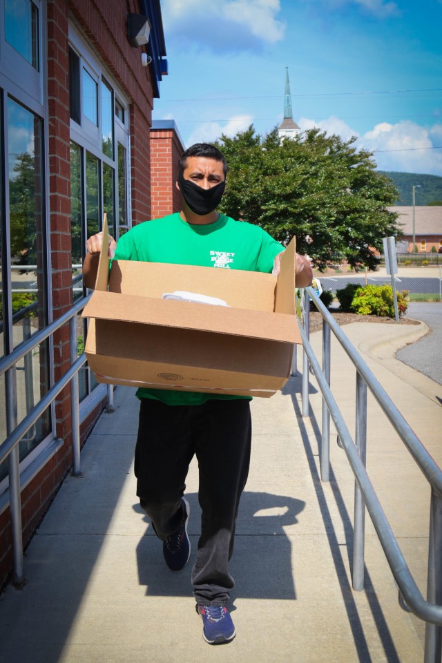 North Carolina Army National Guard Spc. Acevedo Enrique, assigned to the 875th Engineer Company, loads meals into a van to distribute to the children of Buncombe County at the Johnston Elementary School in Asheville, N.C., June 26, 2020. The NCNG...