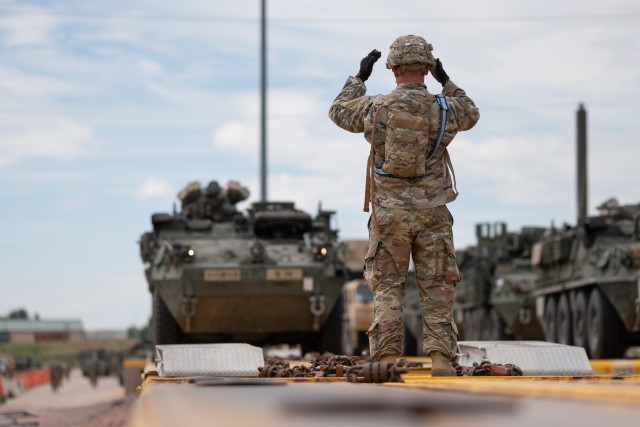 Staff Sgt. Shawn Mercer, a cavalry scout assigned to Alpha Troop, 4th Squadron, 10th Cavalry Regiment, 3rd Armored Brigade Combat Team, 4th Infantry Division, guides a Stryker onto a railcar at Fort Carson, Colorado, July 23, 2020. The 3rd ABCT provided support to 1st Stryker Brigade Combat Team's no-notice Emergency Deployment Readiness Exercise. (U.S. Army photo by Capt. Daniel Parker)