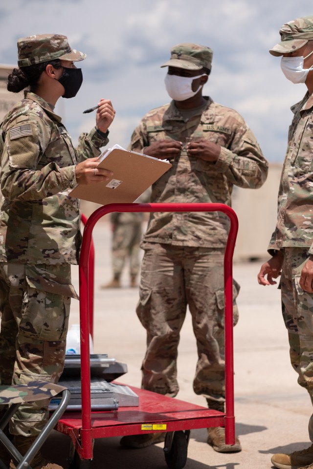 Sgt. Lorelyna Sierra, an army transportation management coordinator assigned to 152nd Movement Control Team, 4th Special Troops Battalion, 4th Infantry Division Sustainment Brigade, inspects paperwork and provides feedback to Soldiers assigned to 2nd Battalion, 12th Field Artillery Regiment, 1st Stryker Brigade Combat Team, 4th Infantry Division, in preparation for 1st SBCT's upcoming rotation to the National Training Center and to meet objectives for the brigade's Emergency Deployment Readiness Exercise (EDRE) at Fort Carson, Colorado, July 16, 2020. The 1st SBCT received the mission to execute a no-notice EDRE on July 15. (U.S. Army photo by Capt. Daniel Parker)