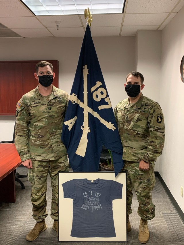 Captain Hampton Moore, commander of A Company 1st Battalion, 187th Infantry Regiment, 101st Airborne Division (Air Assault), and 1st Sgt. Jonathan Peters, hold up the company guidon and physical training T-shirt used during the Vietnam War gifted by Weaver Barkman, Vietnam veteran of A Co., 1-187th Inf. Regt. (Contributed, U.S. Army, released)