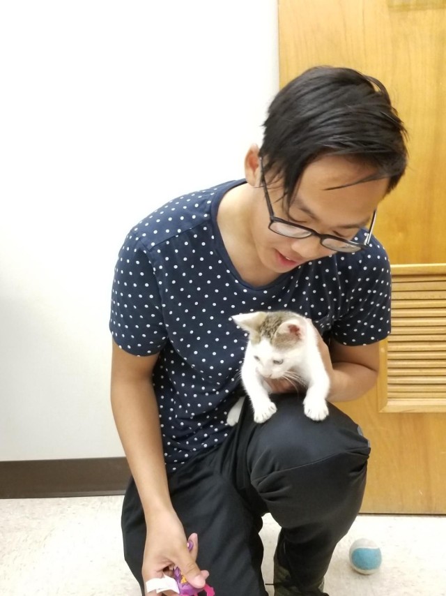 Spc. Newton Vang, 32nd Hospital Center, stops by the Fort Polk Veterinary Treatment Facility to officially adopt Ronin and take him home.