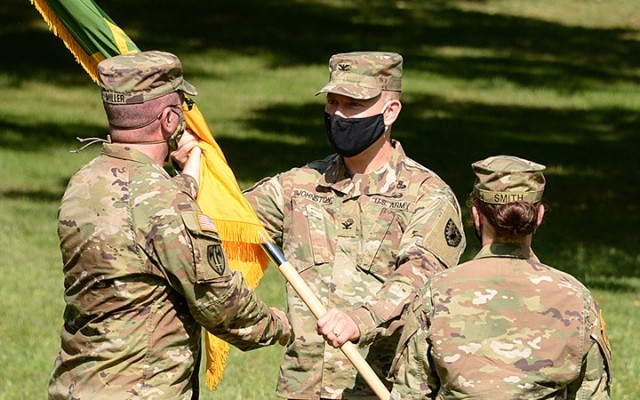 After receiving the colors from outgoing 15th Military Police Brigade Commander Col. Caroline Smith, right, U.S. Army Corrections Command Commanding General Brig. Gen. Duane Miller passes the colors to incoming 15th MP Brigade Commander Col....
