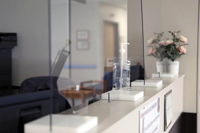 Plexiglas barriers separate staff from patients checking in for appointments at Kleber Army Health Clinic.