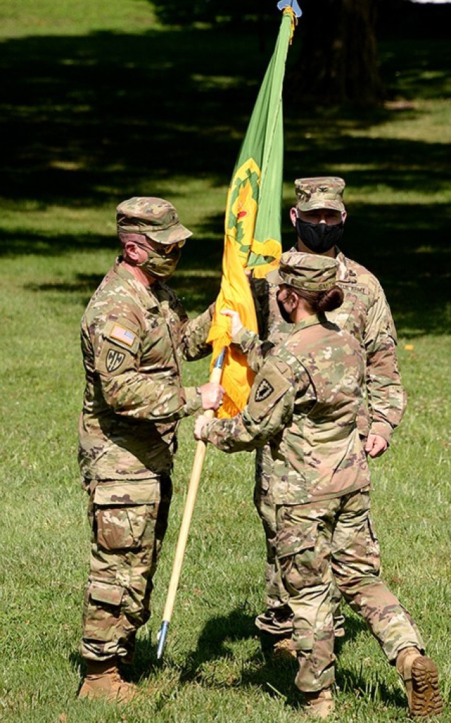 Outgoing 15th Military Police Brigade Commander Col. Caroline Smith, right, passes the colors to U.S. Army Corrections Command Commanding General Brig. Gen. Duane Miller during her change of command ceremony with incoming 15th MP Brigade Commander...