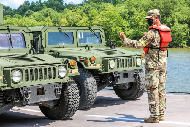 Staff Sgt. Shawn Pursifull, an intelligence analysis assigned to D Company, 39th Brigade Engineer Battalion, 2nd Brigade Combat Team, 101st Airborne Division (Air Assault), guides two vehicles onto a barge July 21, 2020, at Lock C on the...