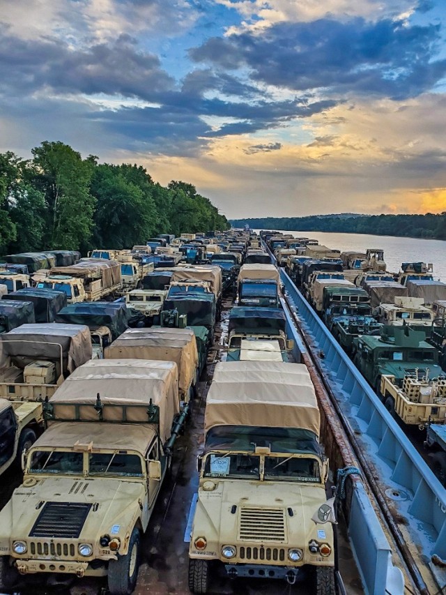Vehicles and equipment assigned to 2nd Brigade Combat Team, 101st Airborne Division (Air Assault), are loaded on a barge and prepared to depart July 20, 2020, from Lock C on the Cumberland River, Tennessee, as the sun sets. The equipment will...