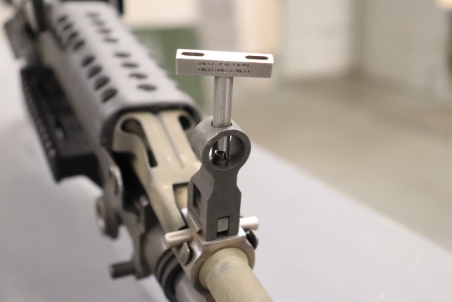 A close-up of an M249 sight adjustment tool inserted into the front sights of an M240 machine gun. (Photo by Randl Besse, Deputy Project Manager Rock Island Arsenal, Joint Manenterufacturing Technology Center).