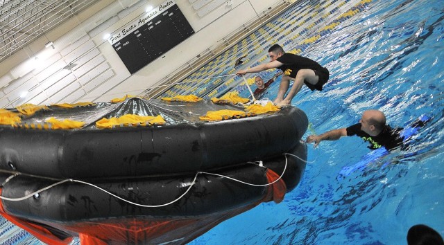 Pfc. Juan CintronGonzalez attempts to flip over a life raft during 88L Watercraft Engineer Course training July 24 at the Fort Eustis Aquatics Center. Watercraft engineer students undergo the training to prepare for emergencies at sea.