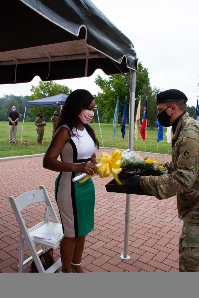 Mrs. Razell Perry, wife of incoming command sergeant major of the 1st Theater Sustainment Command, Command Sgt. Maj. Michael J. Perry III, receives a bouquet of yellow roses during the change of responsibility ceremony held at Fort Knox, Kentucky, July 28, 2020. The roses represent the command’s warmest welcome to the 1st TSC. (U. S. Army Photo by Spc. Jimmie Baker, 1st TSC Public Affairs)