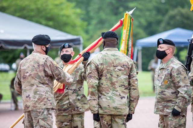 Maj. Gen. John P. Sullivan, commanding general, 1st Theater Sustainment Command, hands the unit colors to Command Sgt. Maj. Michael J. Perry III, incoming senior enlisted advisor, 1st TSC, during a change of responsibility ceremony held at Fort Knox, Kentucky, July 28, 2020. (U. S. Army Photo by Spc. Kaylee Harris, 1st TSC Public Affairs)