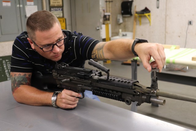 David Blaylock, Simulation & Test Range Division chief at Rock Island Arsenal – Joint Manufacturing Technology Center, uses an M249 sight adjustment tool on the front sights of an M240 machine gun. (Photo by Randl Besse, Deputy Project Manager, Rock Island Arsenal, Joint Manufacturing Technology Center)