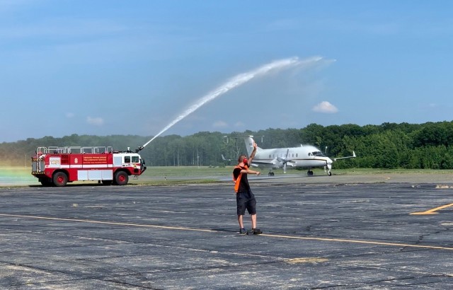 Jon Gregory pilots the CARA C-12J2 (the only one in the Army aircraft inventory) down the Phillips Airfield runway under the aviator’s traditional “hose down” welcome during his last flight.