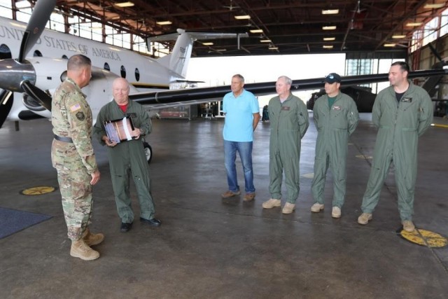 Standing next to their C-12J2 aircraft, Jon Gregory, with CARA teammates, receives the Army Risk Management Award, on behalf of the Army Aviation Safety Center, from Brig. Gen. William King in 2017.