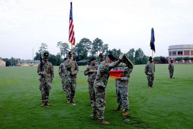 FORT BENNING, Ga. – During a ceremony reactivating the Army's 197th Infantry Brigade here July 31, the brigade's new commander, Col. Bart G. Hensler, draws off the casing that enclosed the unit's colors, which are being held in...